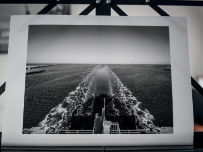 Print van een foto waarop echtpaar dat kijkt naar de aankomst van een ferry in de haven van IJmuiden.